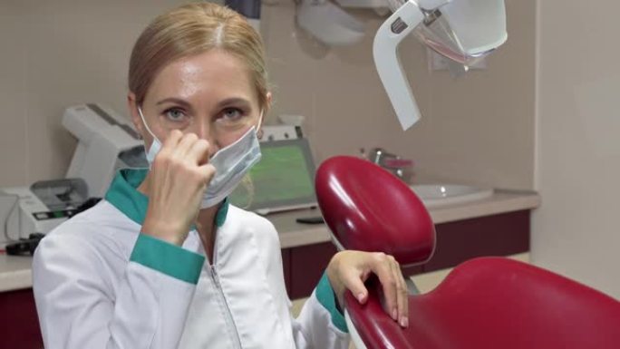 开朗成熟的女牙医摘下医用口罩微笑