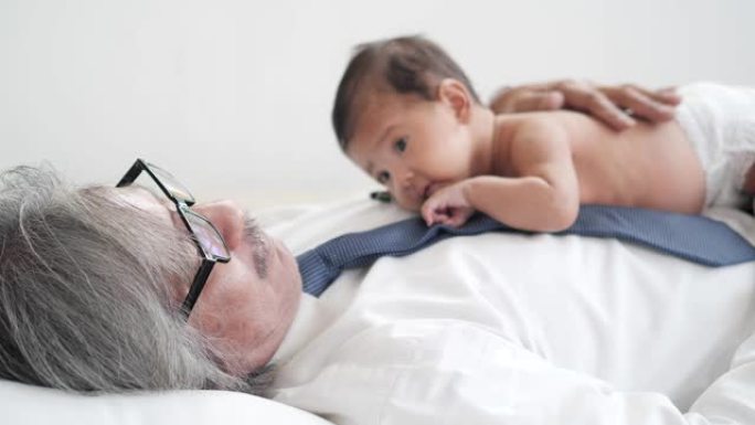 祖父照顾亚洲孙子，在客厅亲吻。