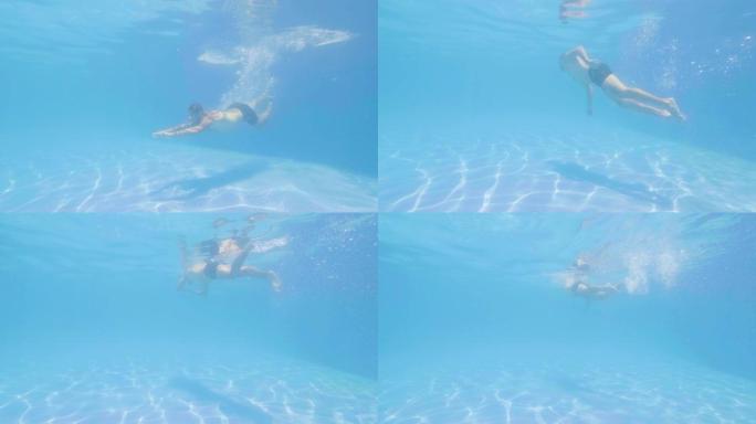 运动员男子在游泳池的蓝色水中跳跃。男子游泳者穿着护目镜潜水，在清水漂浮池下游泳。