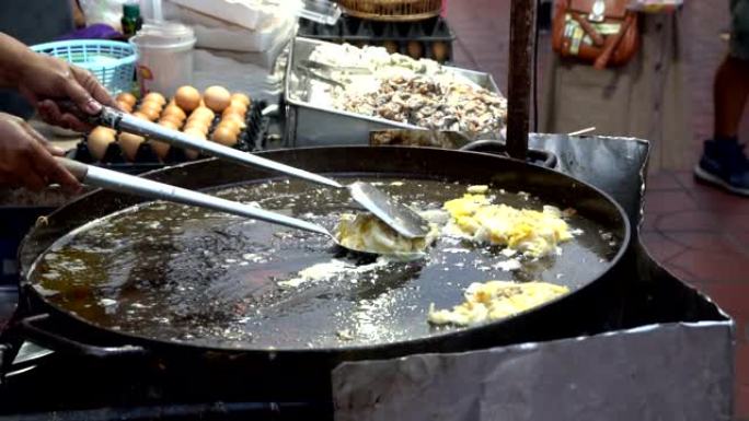 厨师烹饪Hoy Tod脆皮泰国牡蛎煎蛋卷。