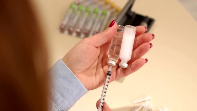 一个女人在胰岛素注射器中提取胰岛素的特写镜头。