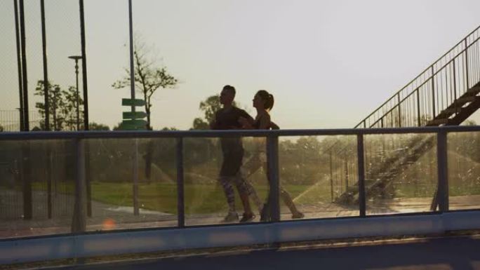 两个人沿着玻璃栏杆奔跑