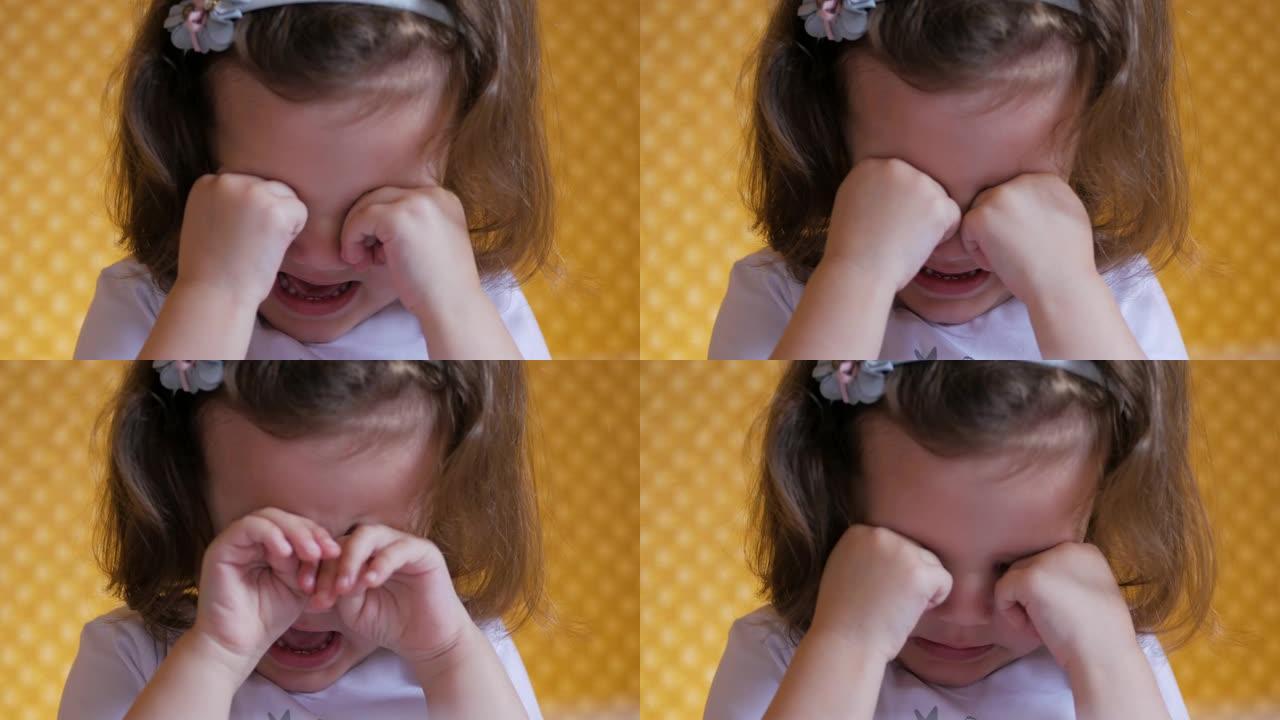 孩子在哭。悲伤的小女孩擦着眼睛哭了。