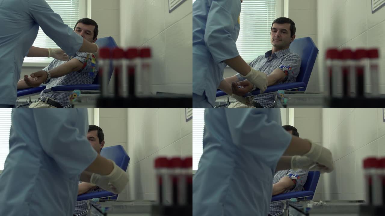 护士的手准备取病人的血液坐在扶手椅的背景。