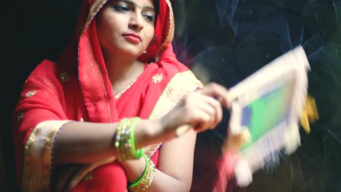 已婚印度教妇女在夏天在家中使用手扇。