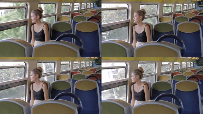 一位美丽的高加索女游客独自坐在空荡荡的地铁车厢里，看着窗外。她身后是空荡荡的排座位。孤独的概念。慢动