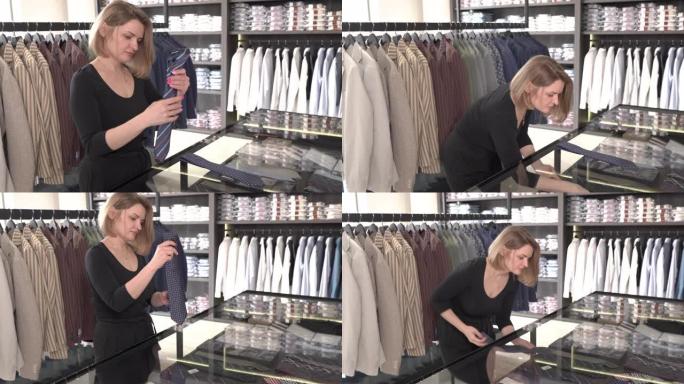 一个年轻迷人的店主在货架上贴上时尚领带的演示视频。时尚精品日常工作