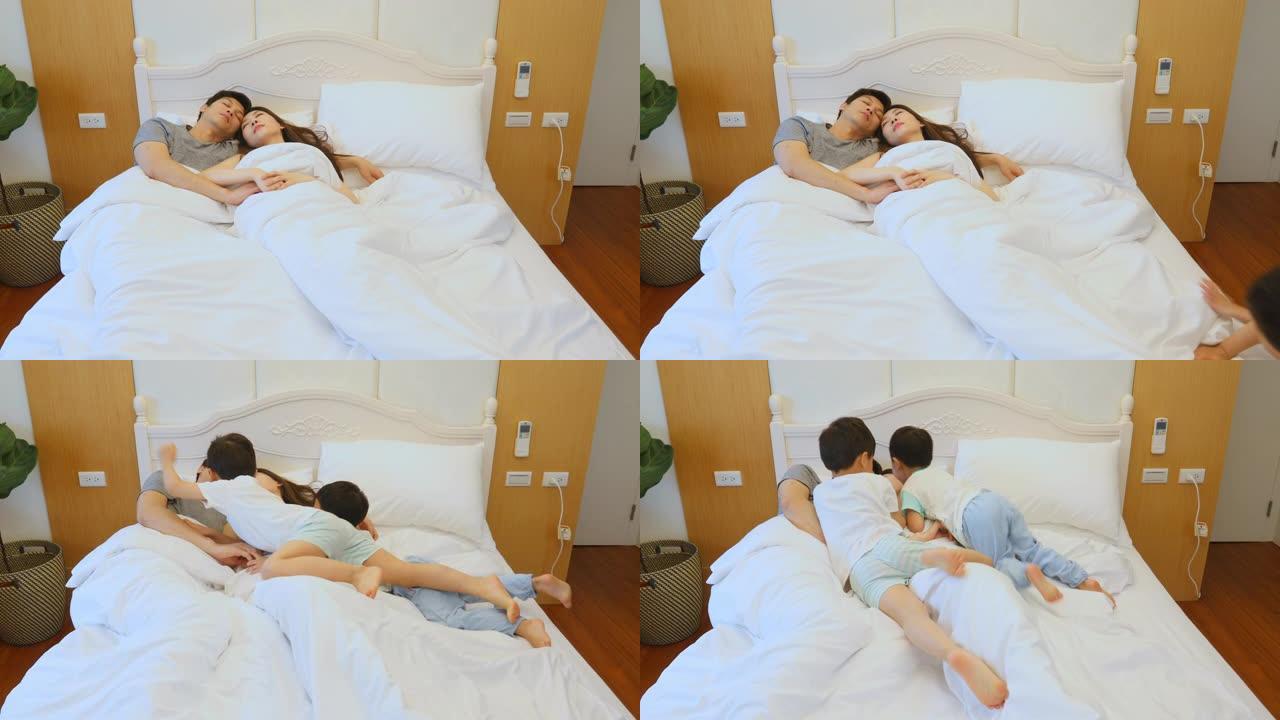 亚洲儿童早上在床上拥抱和与父母玩耍