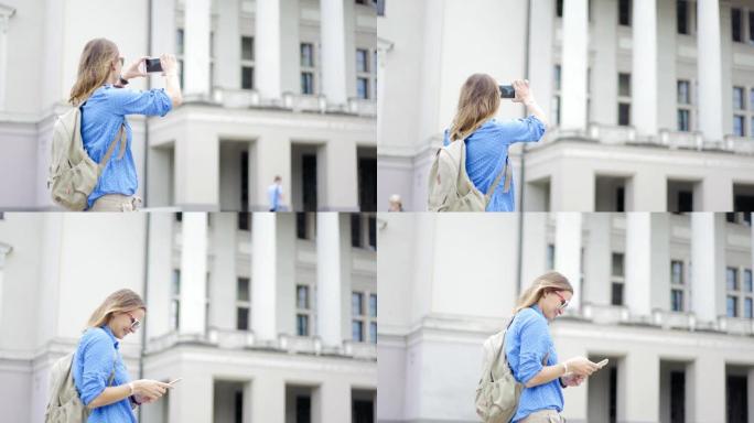 一位年轻的美女旅行者背着背包，用智能手机拍摄了这座历史建筑的照片