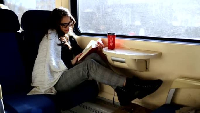 享受旅行。年轻漂亮的女人坐火车在窗户附近旅行。火车概念。