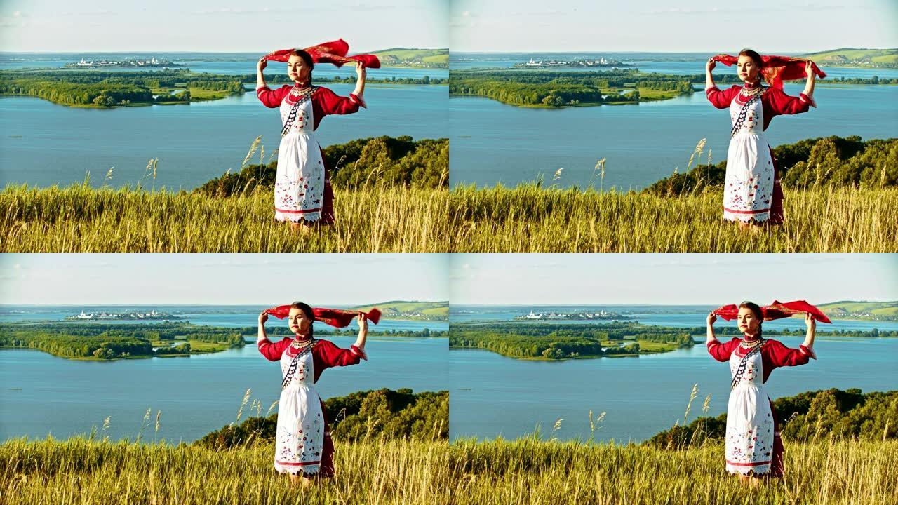 一位穿着俄罗斯民俗服装的年轻女子站在田野上，看着河手帕随风飘扬。