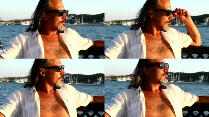游艇甲板上的男人在夏日的阳光下放松