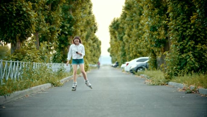 一个穿着旱冰鞋的少女在路上溜冰 -- 看着电话。
