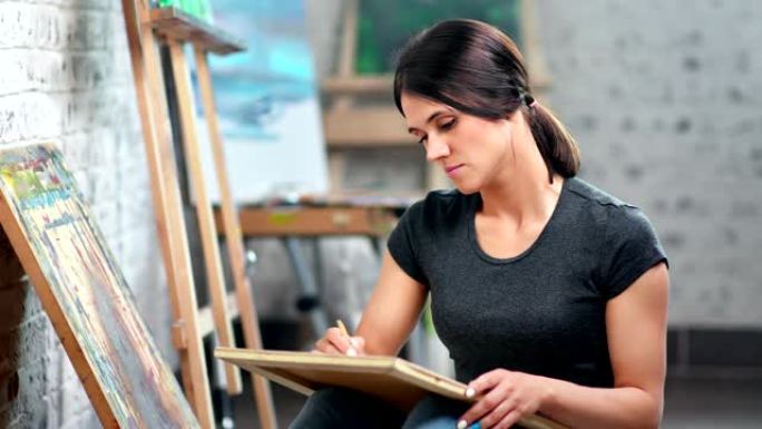 专注的熟练女画家在艺术工作室使用铅笔进行素描