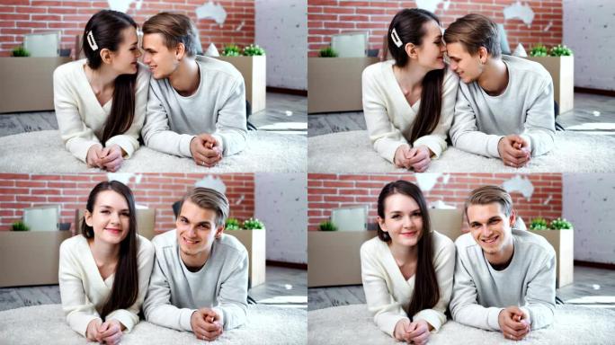 微笑的年轻夫妇享受爱情有温柔的感觉躺在地板上看着相机
