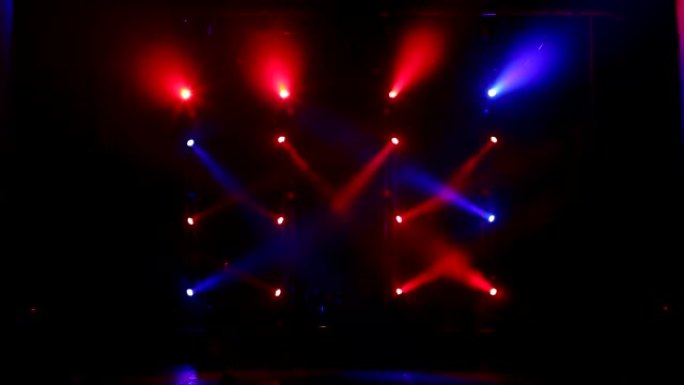 在一场有雾的音乐会上，许多聚光灯照亮了舞台。舞台灯。