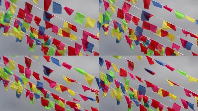 以各种颜色装饰的旗帜在轨道上随风移动，并带有天空背景。