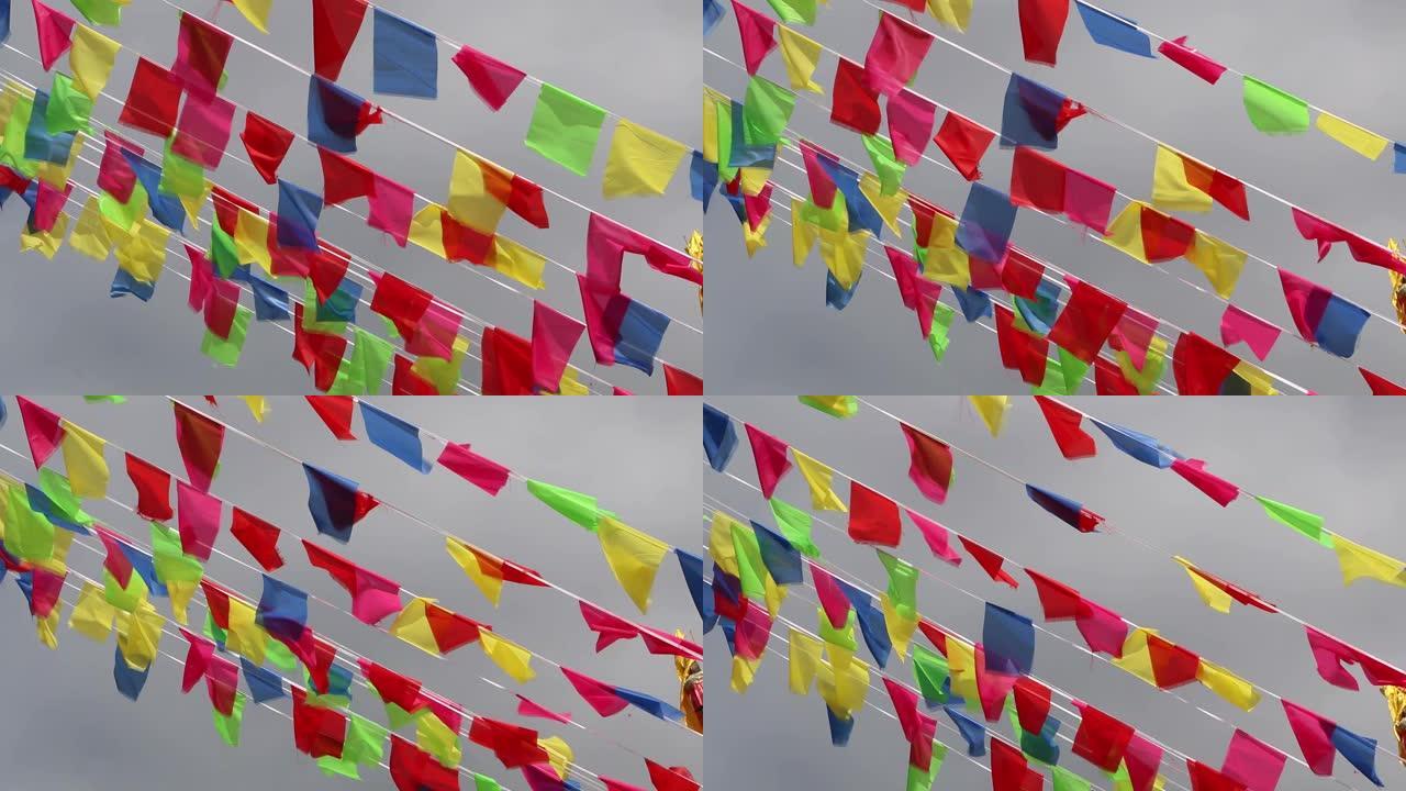 以各种颜色装饰的旗帜在轨道上随风移动，并带有天空背景。