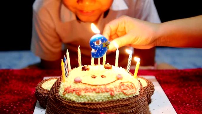 孩子高兴地在他的生日蛋糕上吹蜡烛