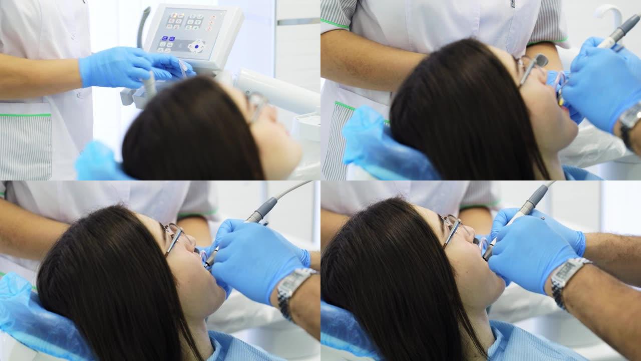 牙医正在钻年轻女性病人的牙齿。