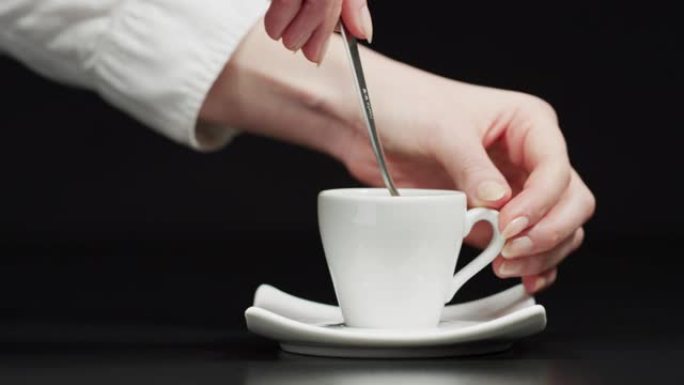 用手搅拌一杯咖啡