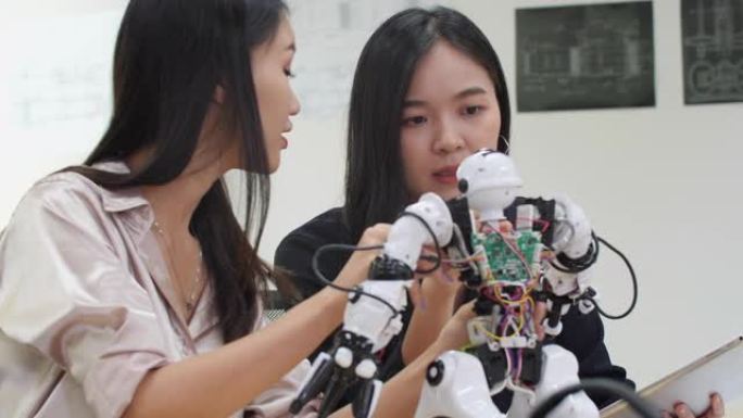 亚洲女工程师在实验室组装和测试机器人反应。建筑师设计电路会议共享技术思想和协作开发机器人。