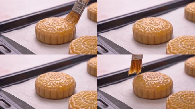 中秋节月饼的制作过程-女士烘烤前在糕点表面刷蛋液。节日自制概念。