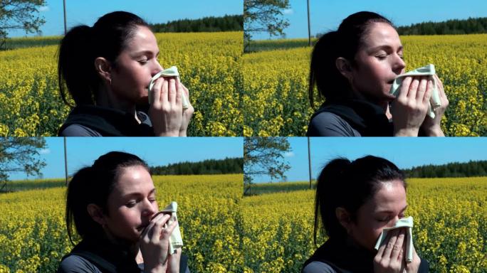 女人在油菜籽花田打喷嚏。花粉过敏概念