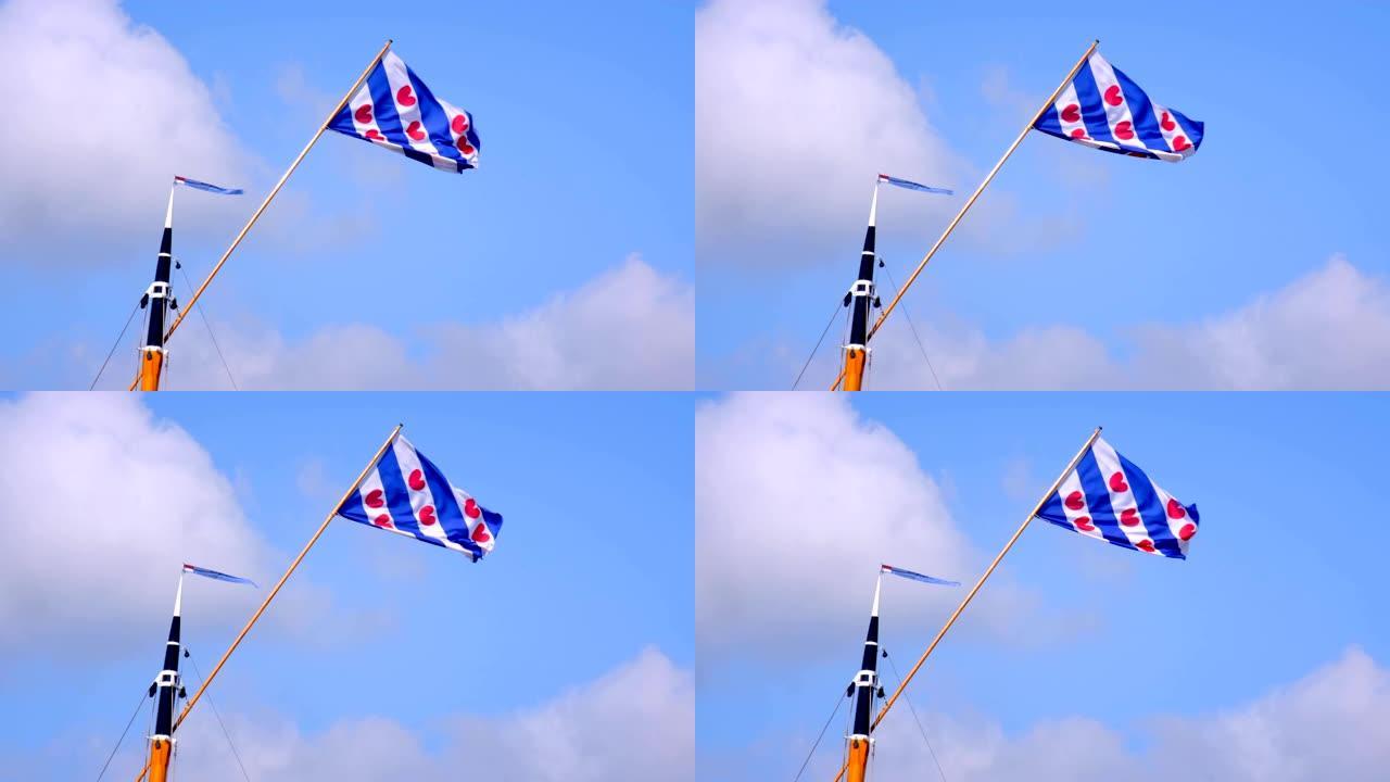 在一个有风的夏天，在一艘经典帆船的桅杆顶部的弗里斯兰旗