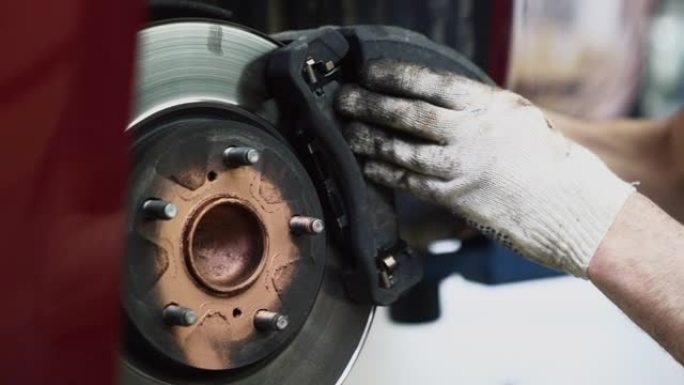 机械师改变汽车上的刹车片系统特写。