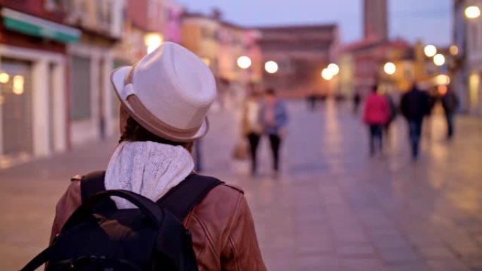 单人旅行者，在意大利威尼斯布拉诺岛上散步的年轻女性游客。浪漫之城及其典型的威尼斯景点。