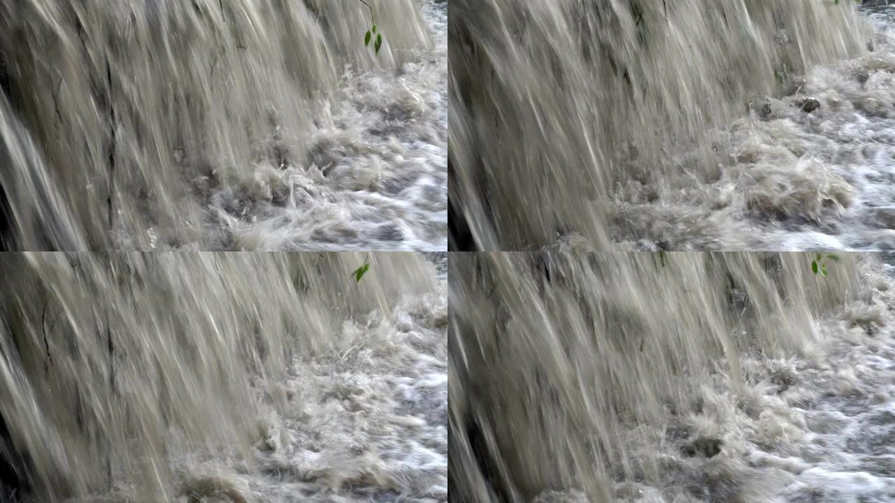 极度接近浑浊的冒泡水涌入河中。小瀑布。特写。4K。