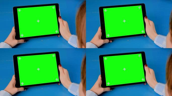 女人看着平板电脑与绿屏-色度键显示概念