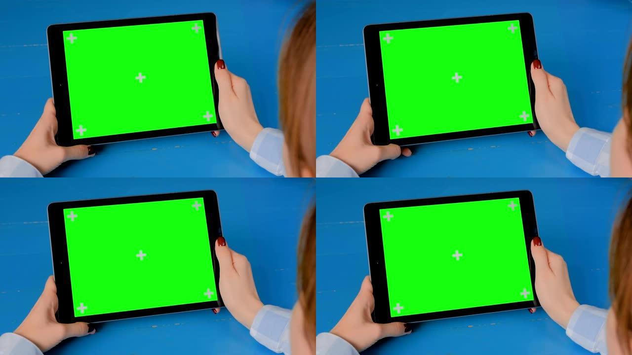 女人看着平板电脑与绿屏-色度键显示概念