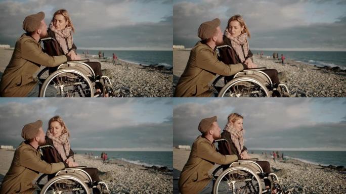 女性轮椅使用者和她的男朋友正在聊天并观看海景