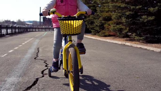 五岁的金发小女孩在一个古老的公园里骑自行车。