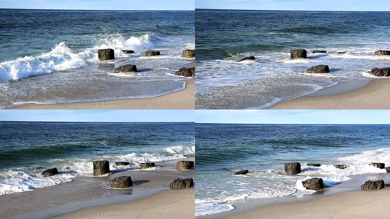 小型大西洋海浪在大部分被沙子掩埋的岩石码头上滚动