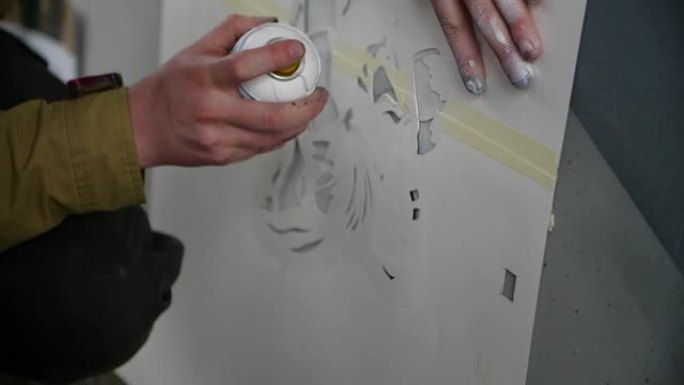 男子用白色喷漆喷漆模板