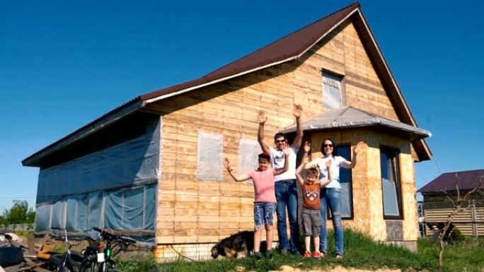 一个年轻的家庭站在木屋的背景上