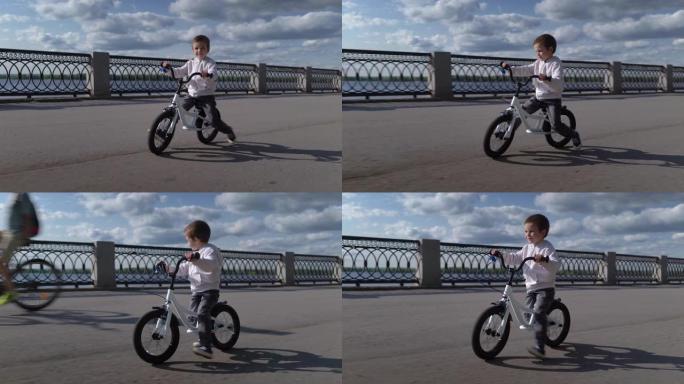 可爱的男孩孩子学习骑第一辆跑步平衡自行车
