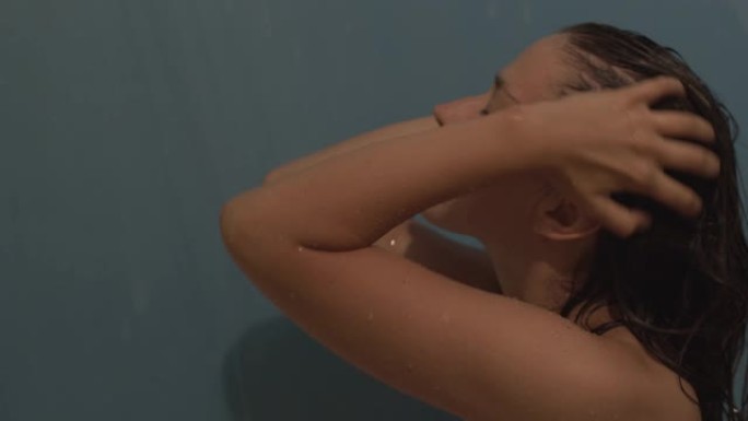 性感的年轻女孩在淋浴时用香波、角质面膜、香油洗发
