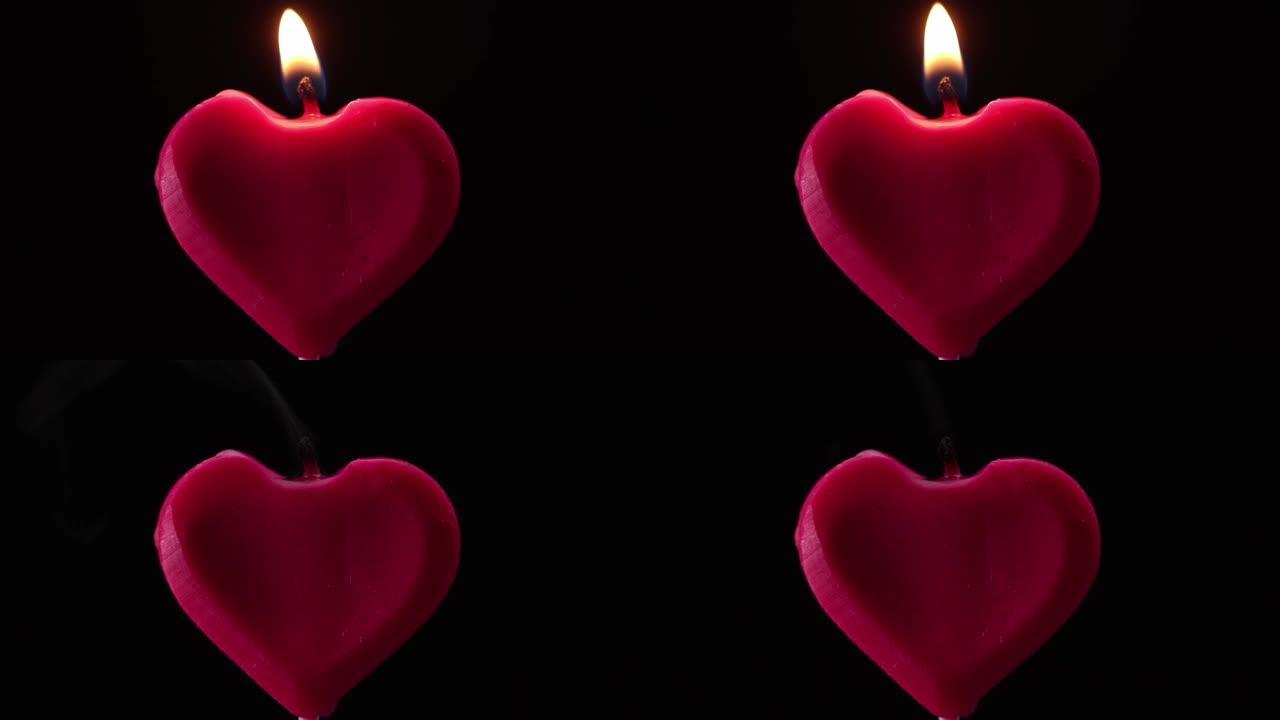 吹出黑色背景上的红色心形蜡烛