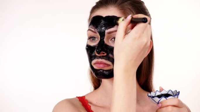 女孩在脸上涂黑色碳面膜