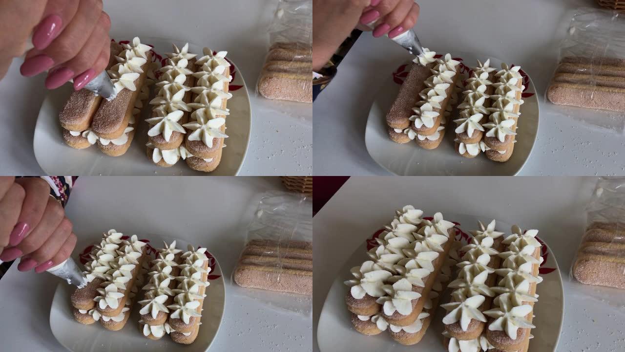 一个女人在savoiardi饼干上涂上奶油。用糕点袋。以花朵的形式