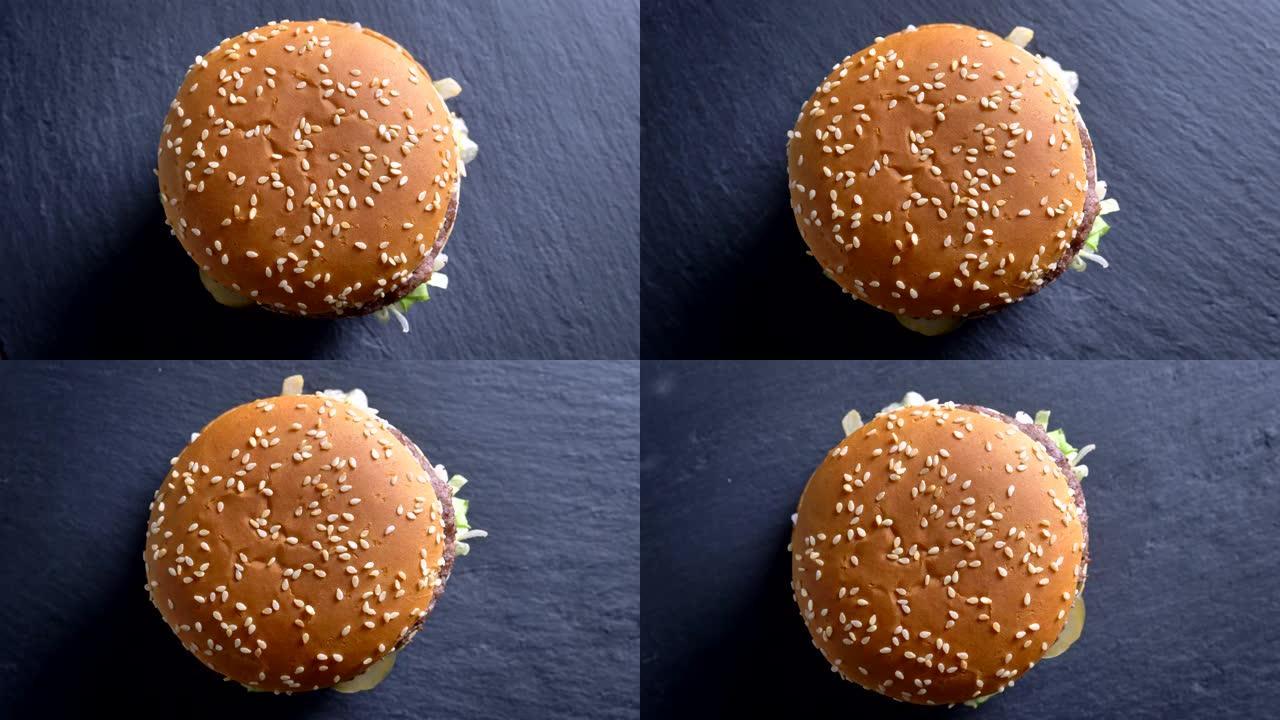 自上而下拍摄开胃的双层芝士汉堡，芝麻在面包上旋转。