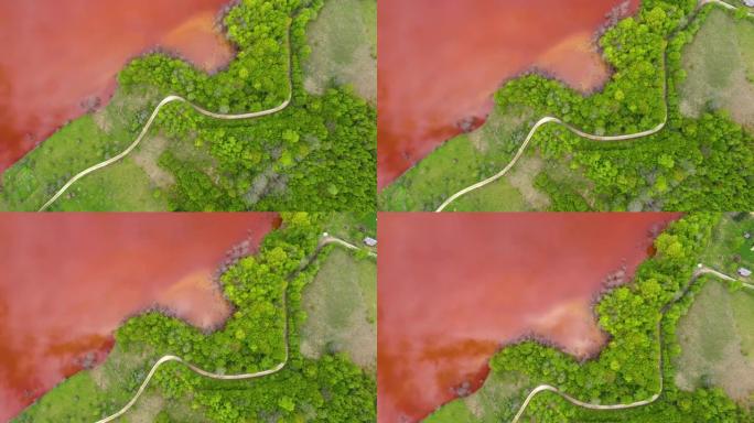 无人机与新鲜的绿色森林形成对比的彩色红铜开采废水的4k空中视图