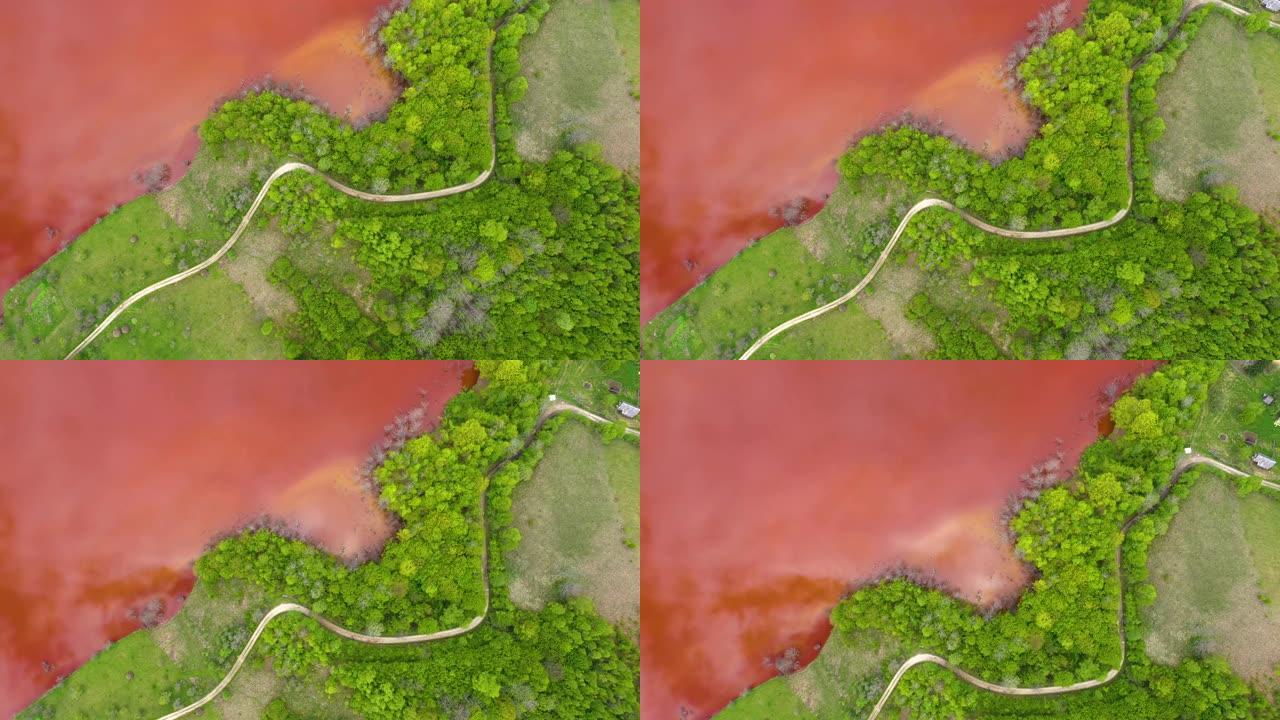 无人机与新鲜的绿色森林形成对比的彩色红铜开采废水的4k空中视图