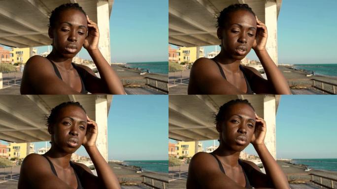 悲伤沉思的美国非洲裔妇女在海滩上。沮丧的孤独黑人妇女