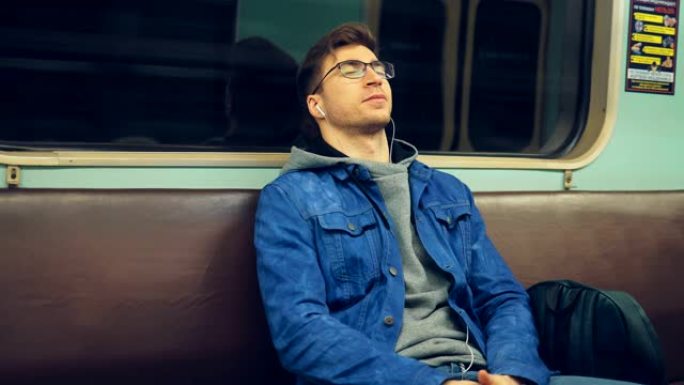 时髦的家伙在空车里闭着眼睛听音乐。年轻人坐地铁睡觉。