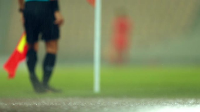 (足球比赛中助理裁判动作的慢镜头散焦，助理裁判在足球比赛中沿着边线移动。
